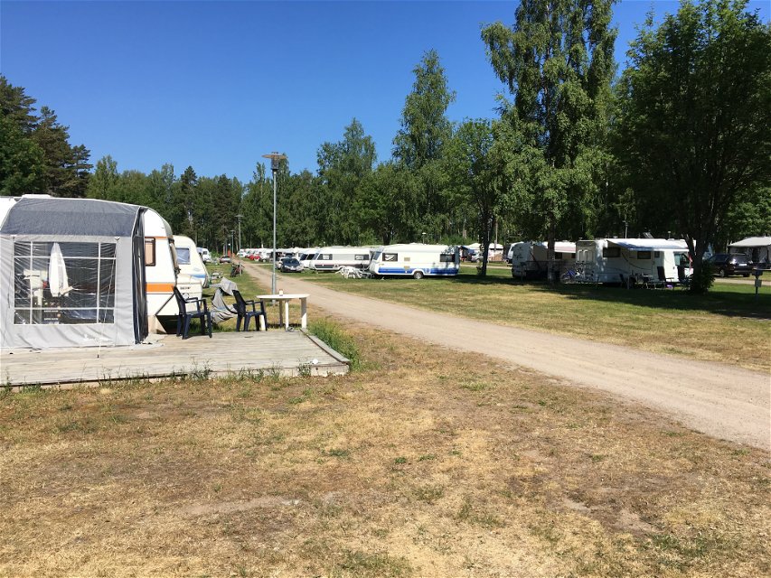 Många husvagnar och husbilar står på en stor campingplats.