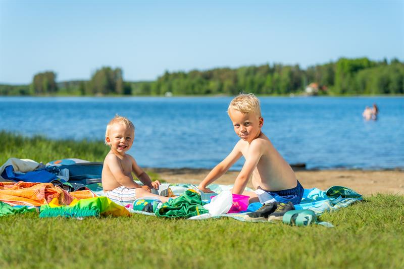 To smågutter som koser seg på hånddukene sine etter en dukkert.