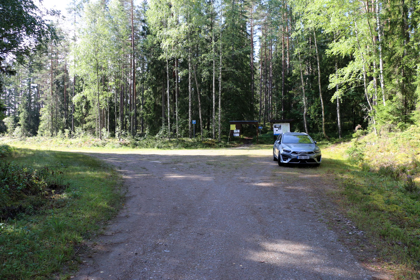 Bil parkerad vi på parkeringsplats i skogen.