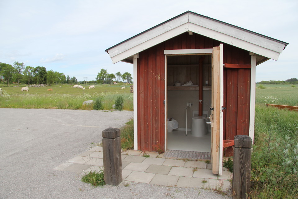 Toalett med öppen dörr.