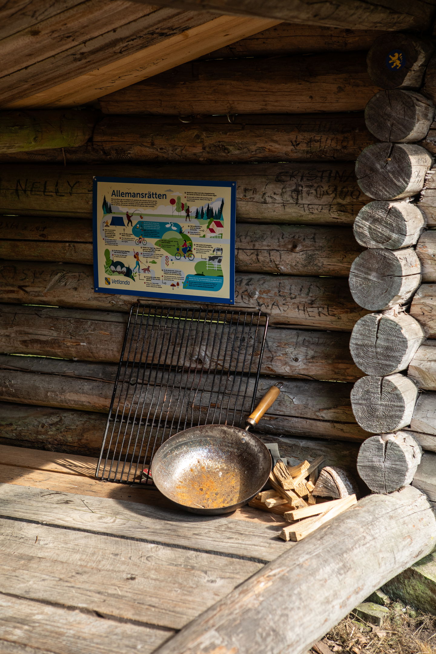 En skylt om allemansrätten hänger i ett vindskydd