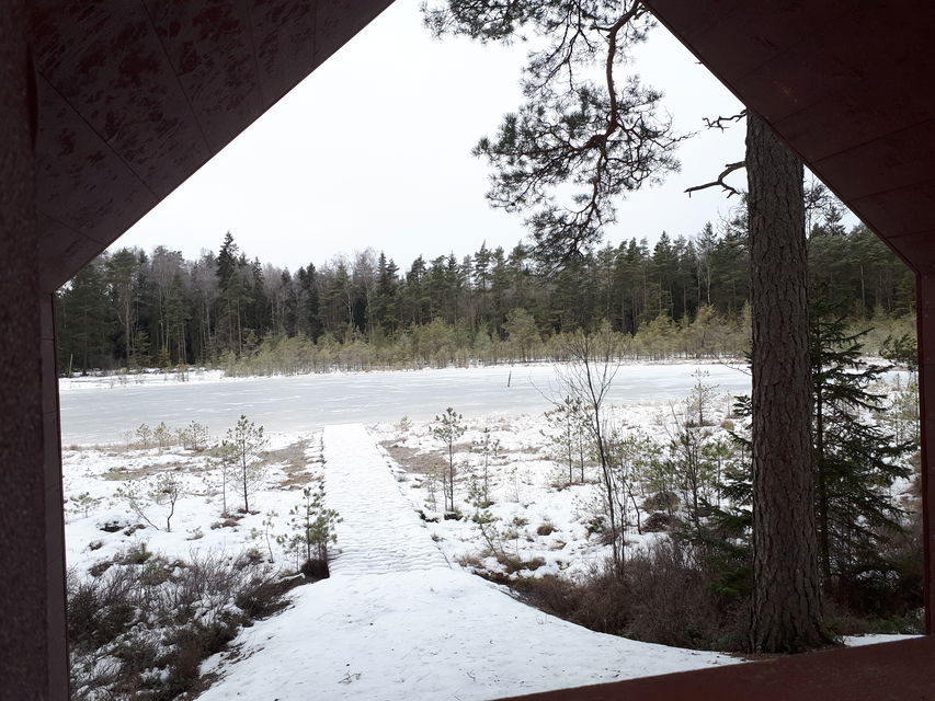 Vy från vindskyddet ut mot en sjö i vinterlandskap