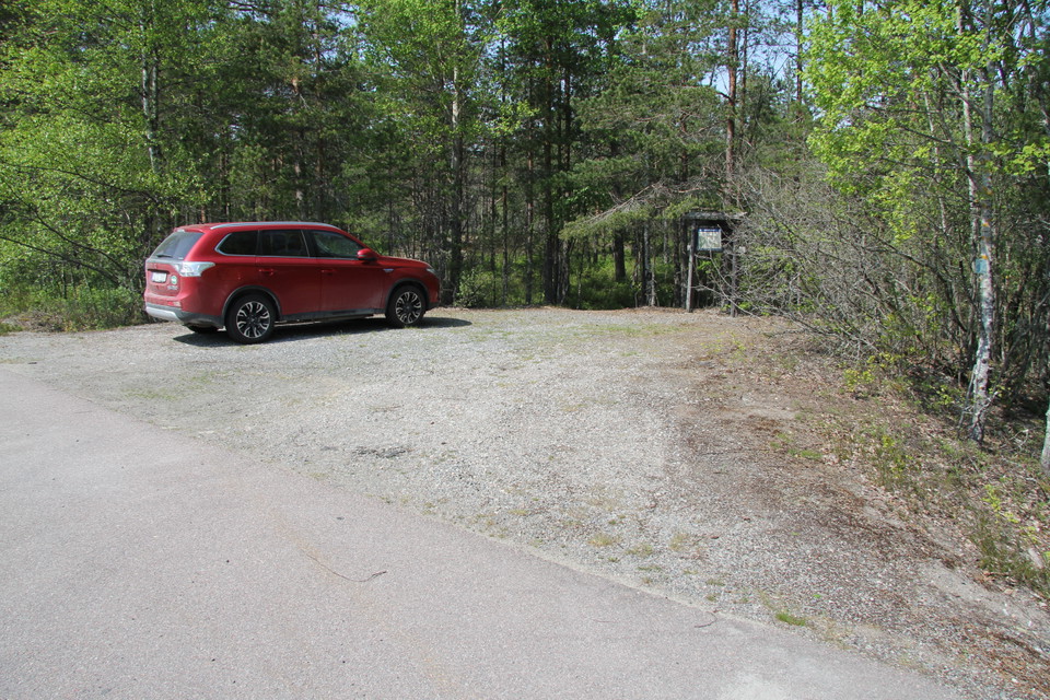 Parkering på grusplan intill landsvägen.