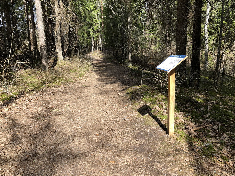 Skylt vid stig och utsiktsplats över gruvhål.