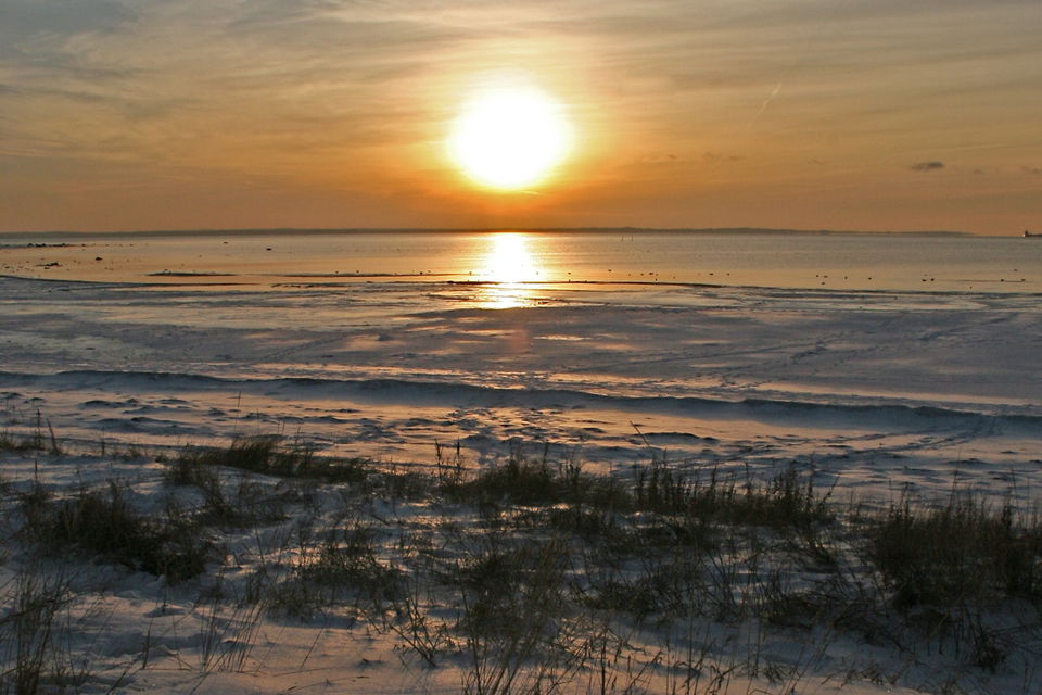 Solnedgång över havet på vintern.