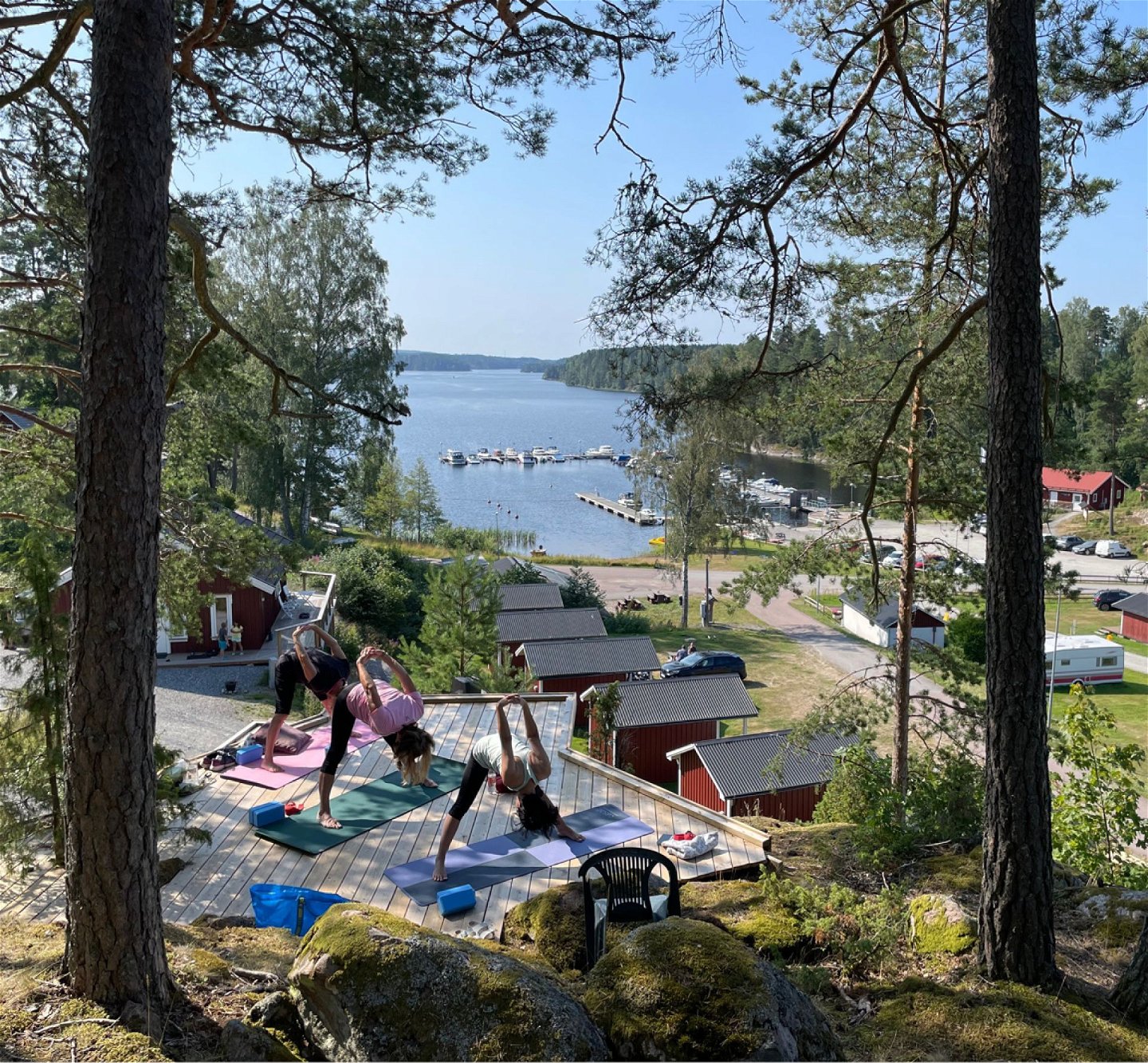 T personer som gör yoga med blick på en sjö