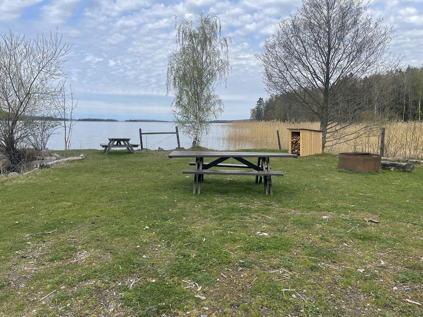 Picknickbord, grillstad och vedförråd.