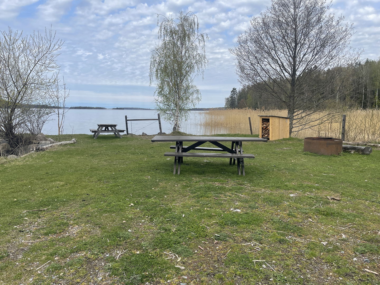 Picknickbord, grillstad och vedförråd.