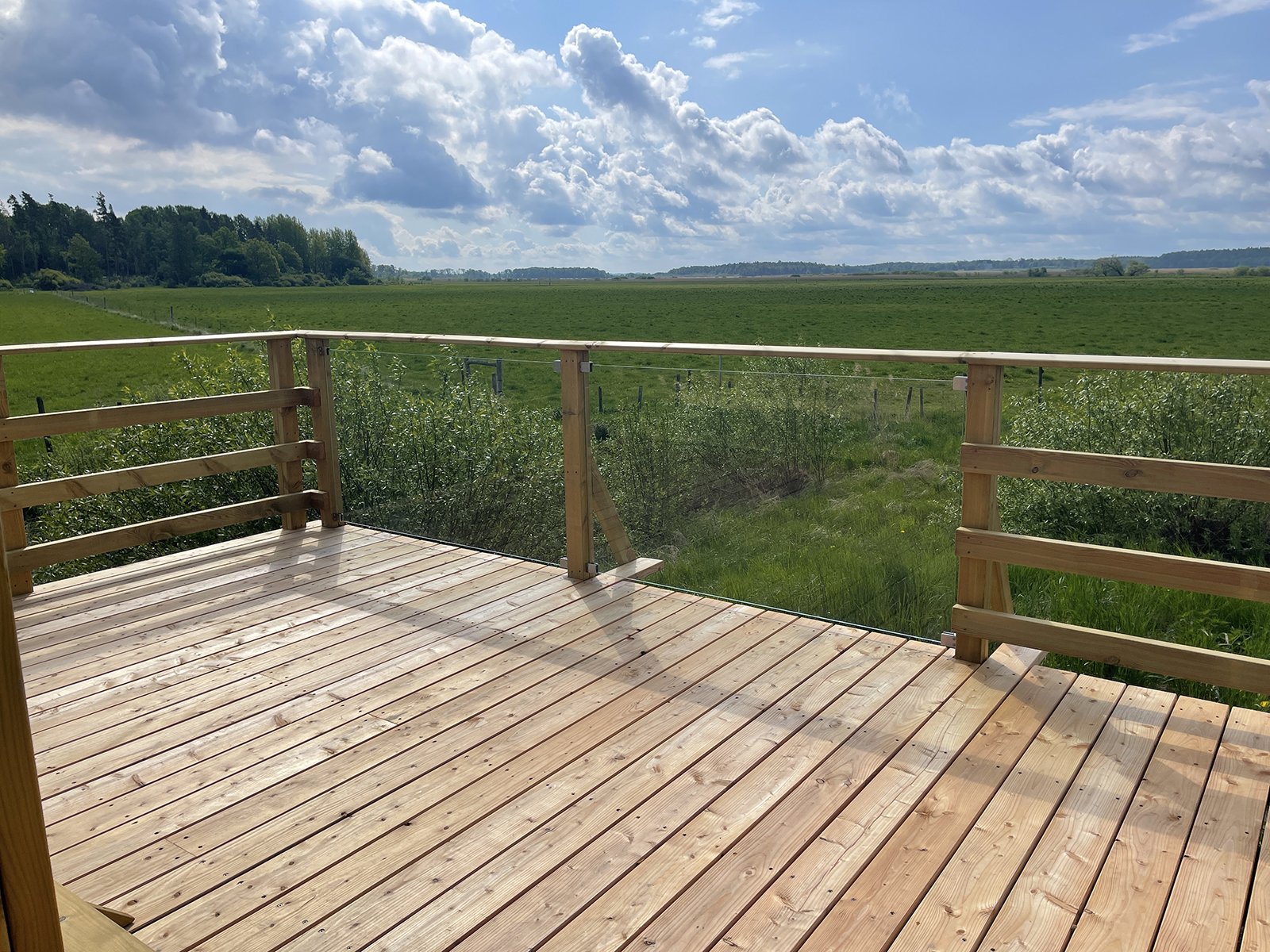 Utsiktsplattform där delar av trä-staketet är ersatt med plexifglas. 