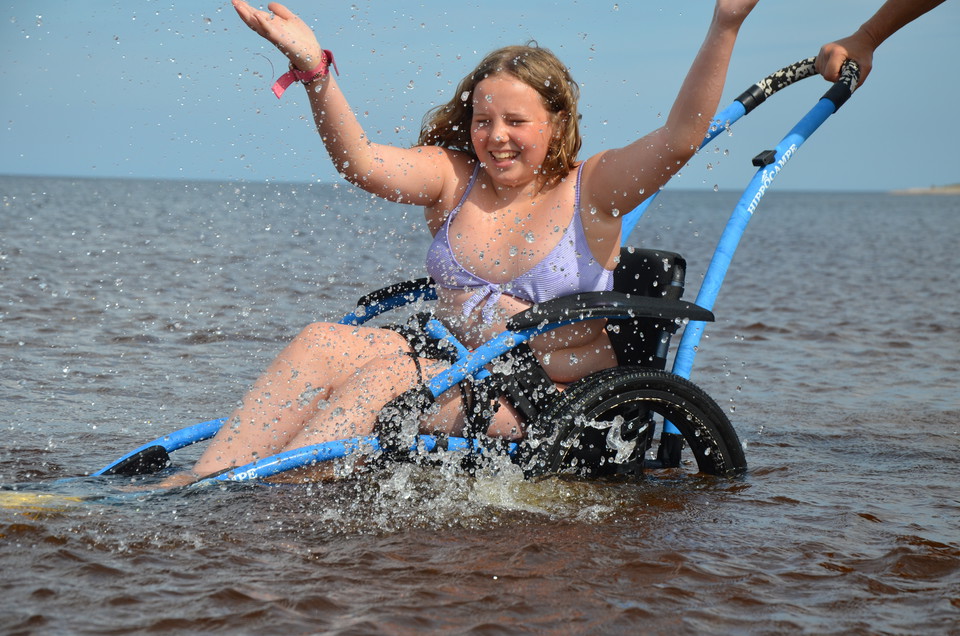 En tjej badar i en badrullstol