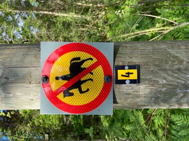 Skylt som visar ridning förbjudet i spåret. Monterad på belysningsstolpe 