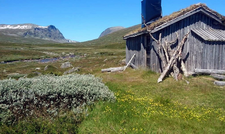 Stuga med Storådörren i bakgrunden