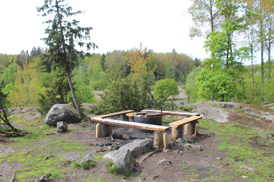 Eldplats med grill och sittbänkar.