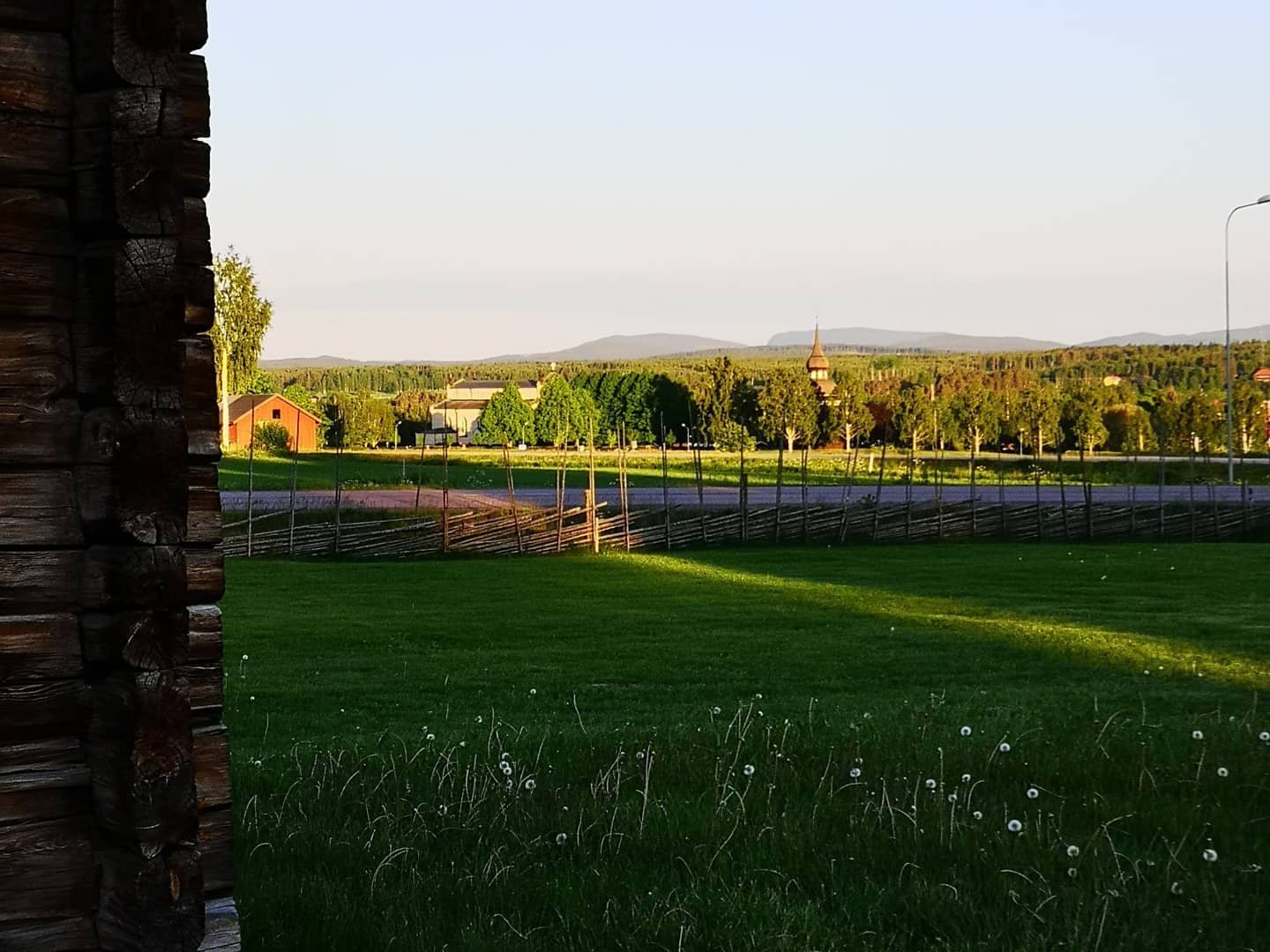 Utsikt mot Delsbo Kyrka, klockstapel och Blacksås i bakgrunden.