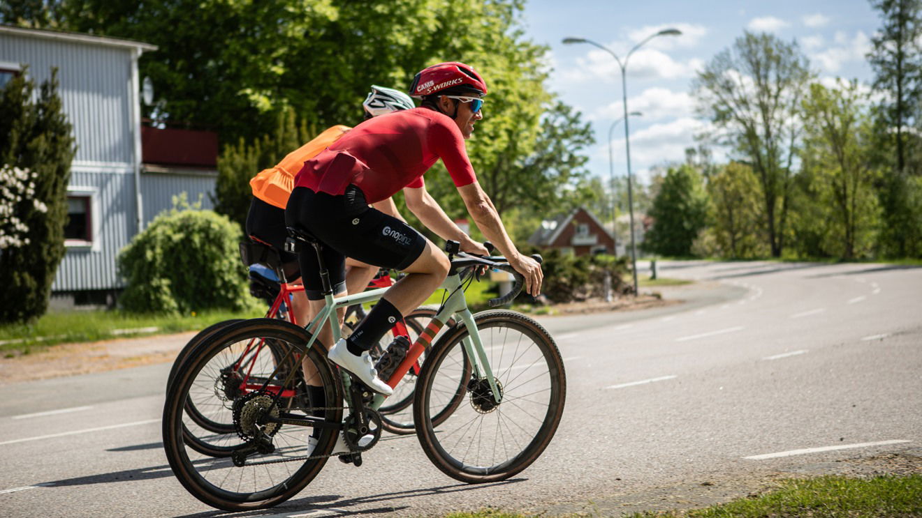 Tre cyklister på en landsväg