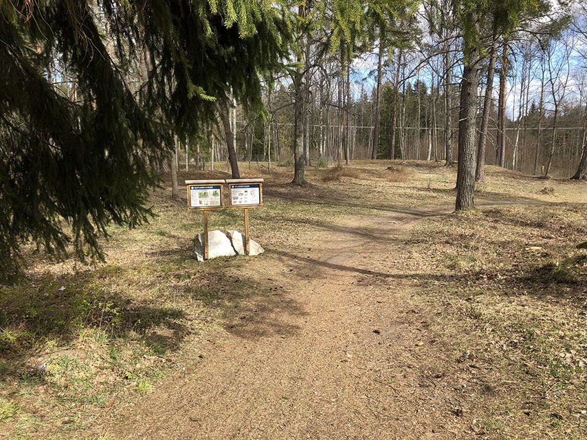 Två informationsskyltar vid en grusad stig.