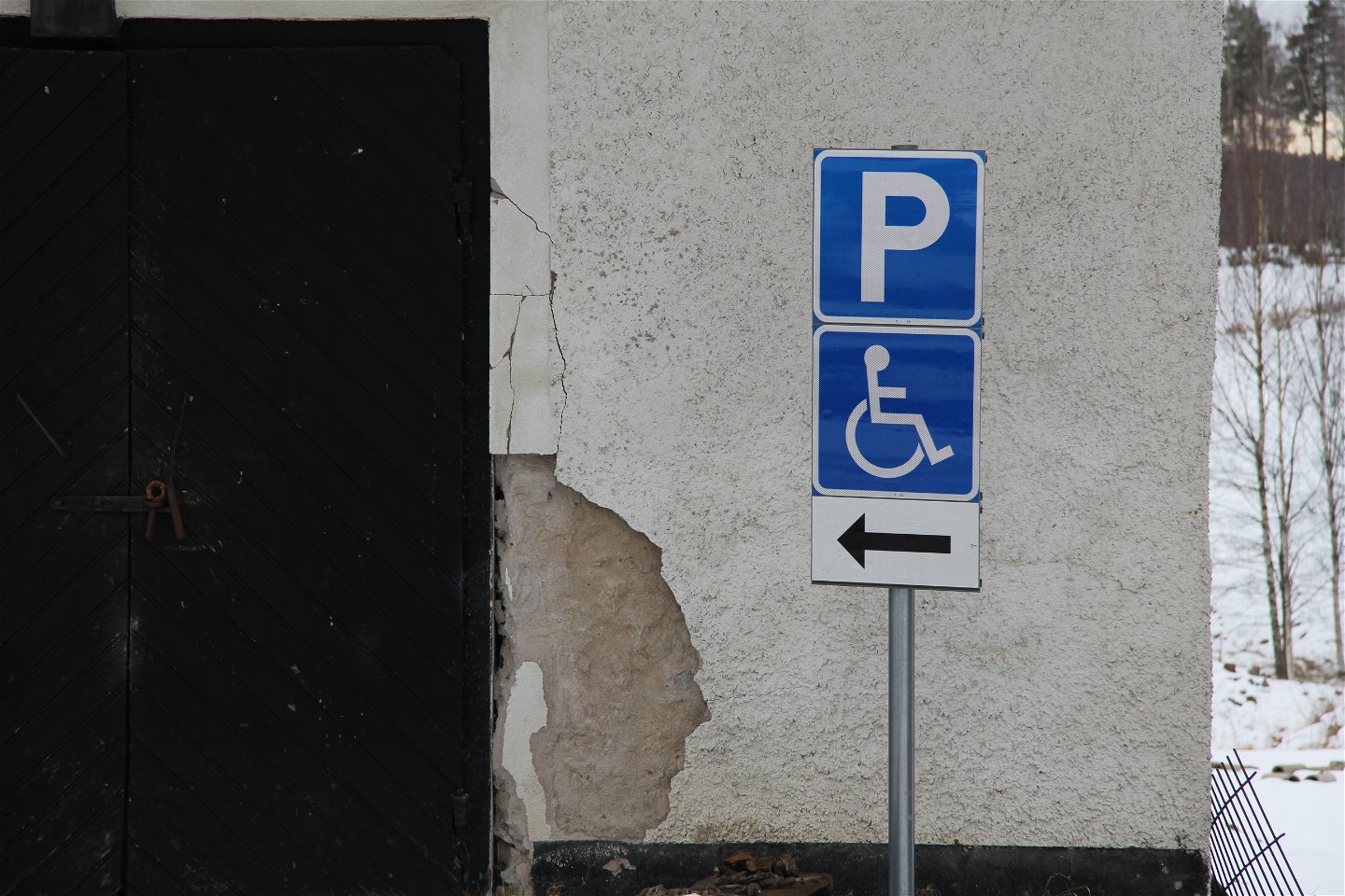Stolpe med skylt som visar parkering och handikapparkering.