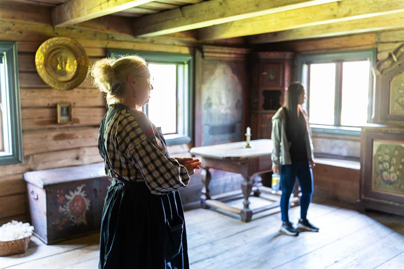 Museumsverten viser rundt i ett av husene på bygdetunet