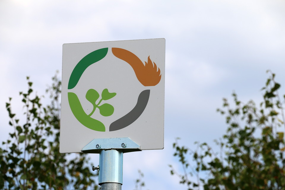 Vit kvadratisk skylt med cirkelformad symbol