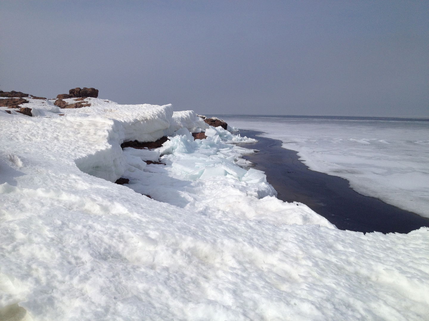 Snötäckta klippor vid havet.