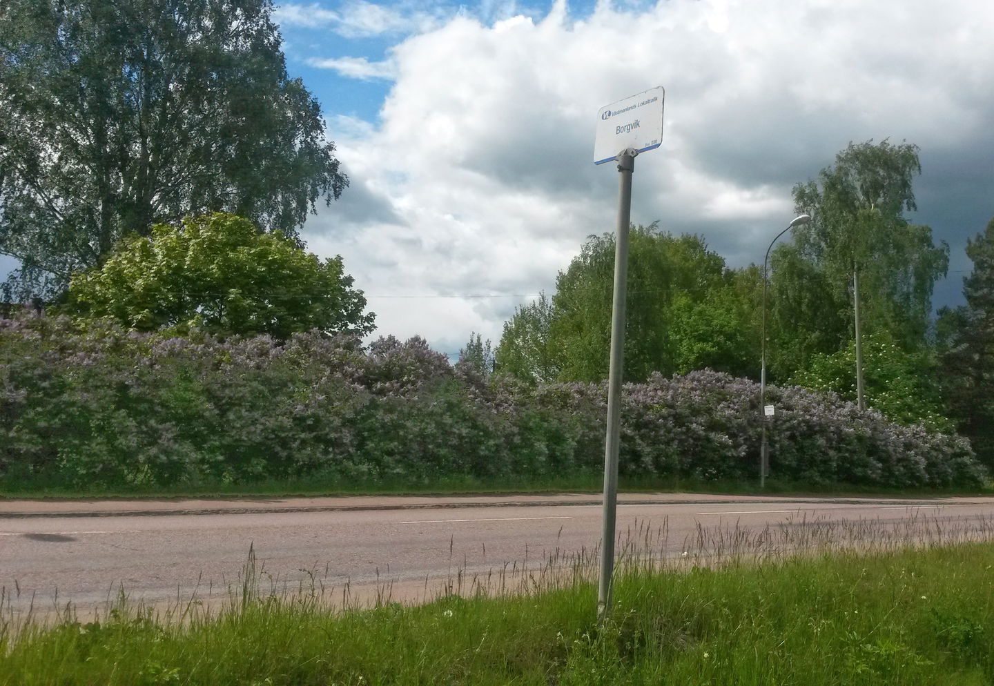 Busshållplats med hållplatsskylt.