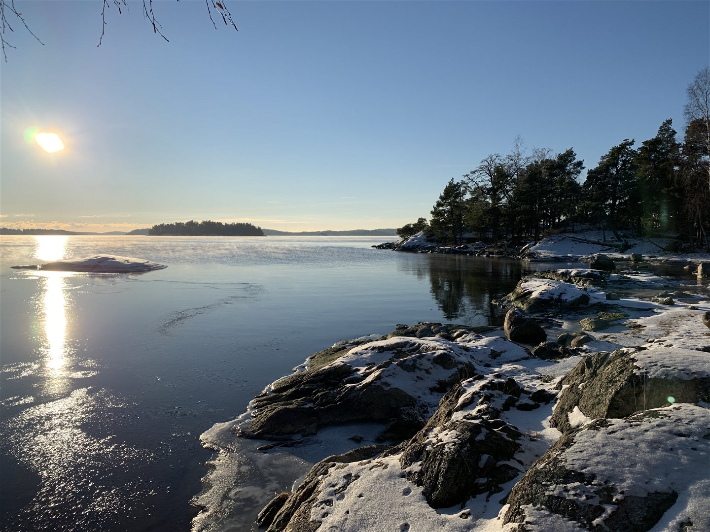 Sol och en antydan till is på Killingströmmens vatten.