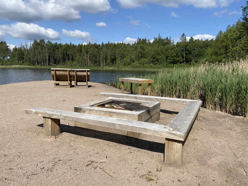 Grillplats och solstolar vid en sjö