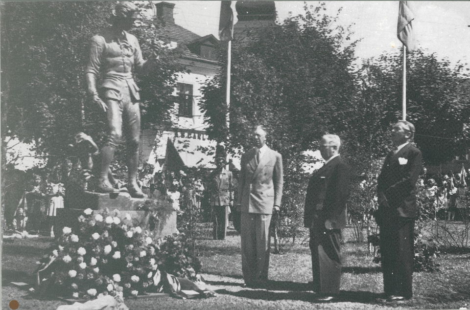 Kronprins Gustav Adolf intill Linnéstatyn när den invigs i juli 1946 på Stortorget i Älmhult. Vid foten på statyn ligger en stor blomsterkrans.