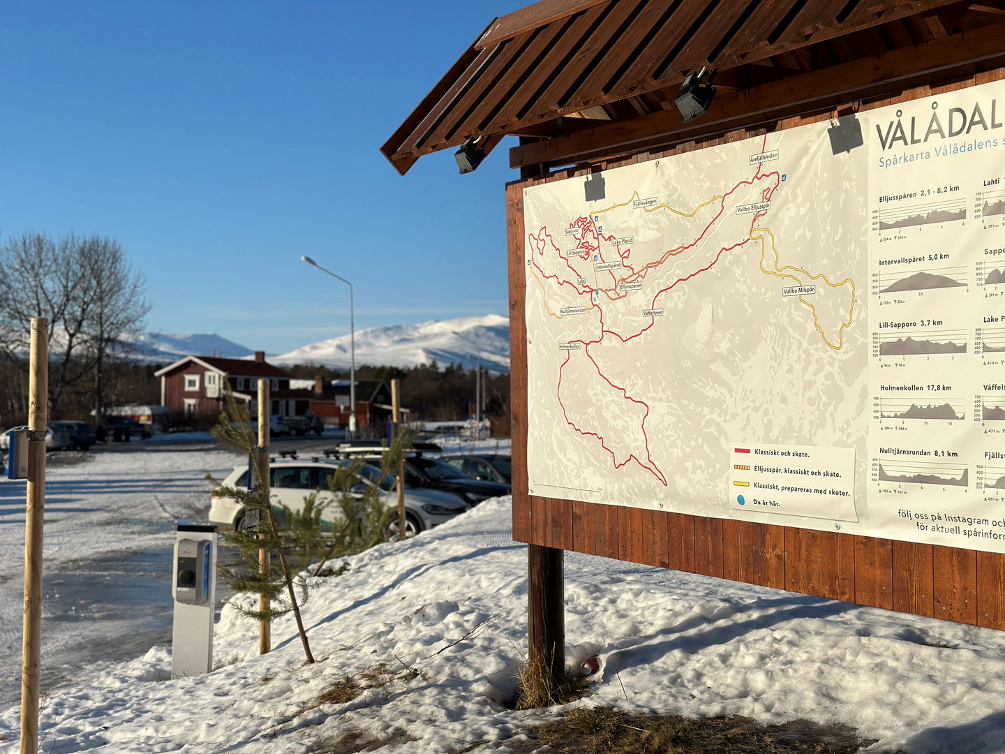 En informationstavla i ett snöigt landskap.