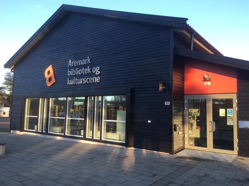 Svart bygg med stor skrift som står Aremark bibliotek og kulturscene.