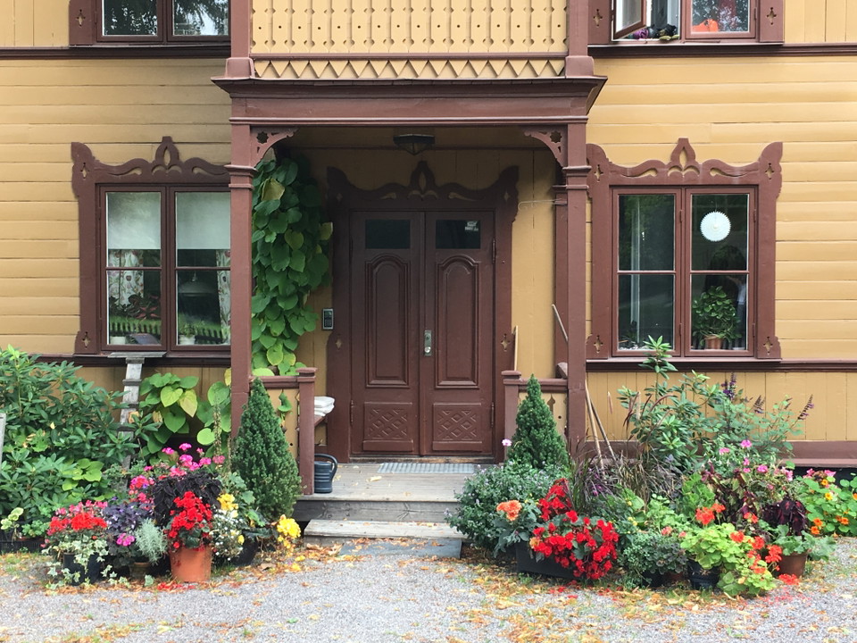 Finnstugan med farstukvist och blommor.