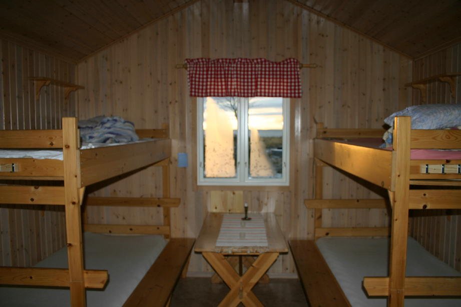 Four beds and a table in a cabin