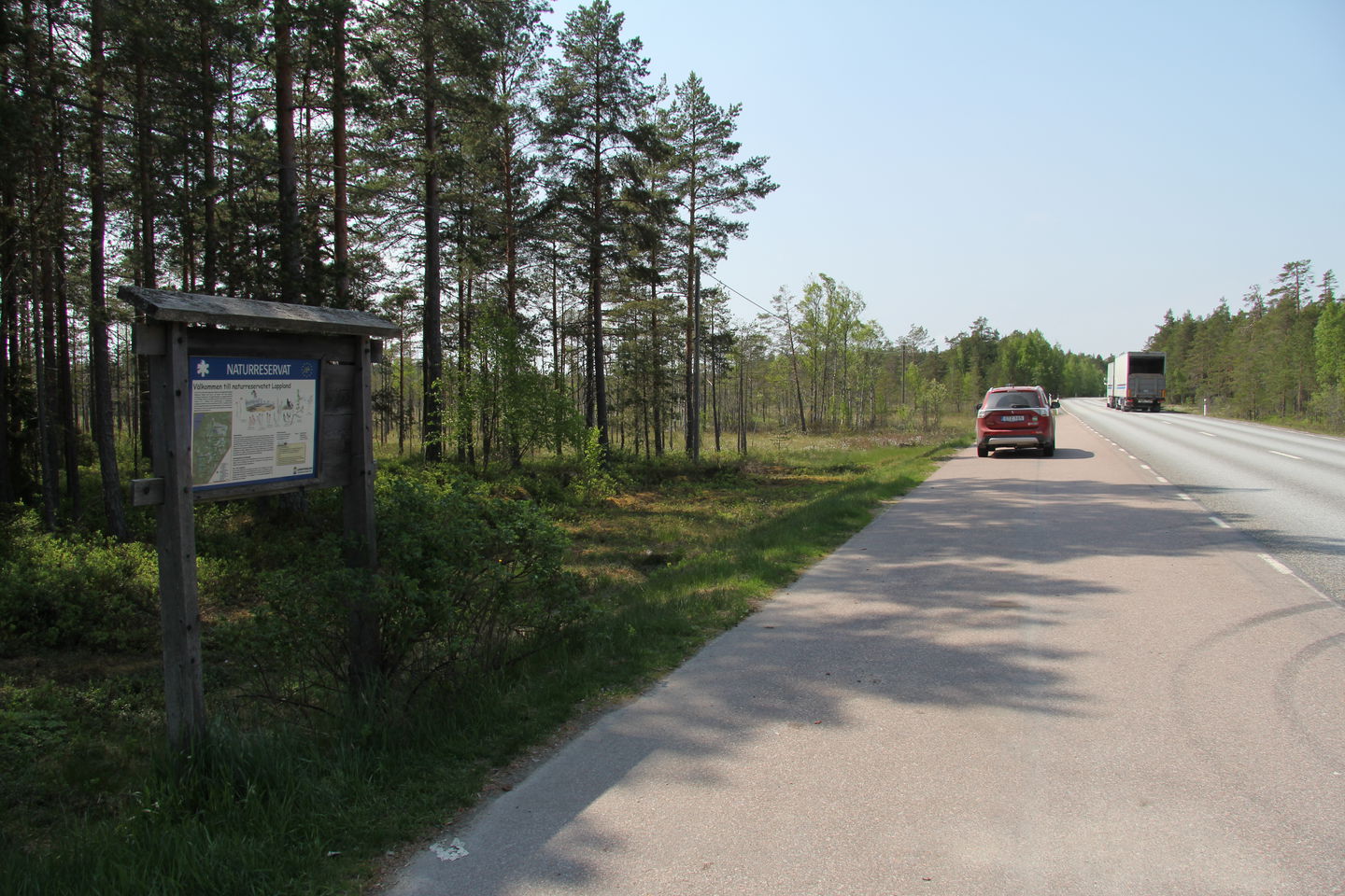 Parkering och informationstavla invid landsvägen.