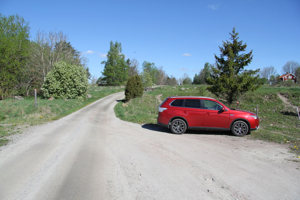 En bil står parkerad vid en ficka längs vägen.