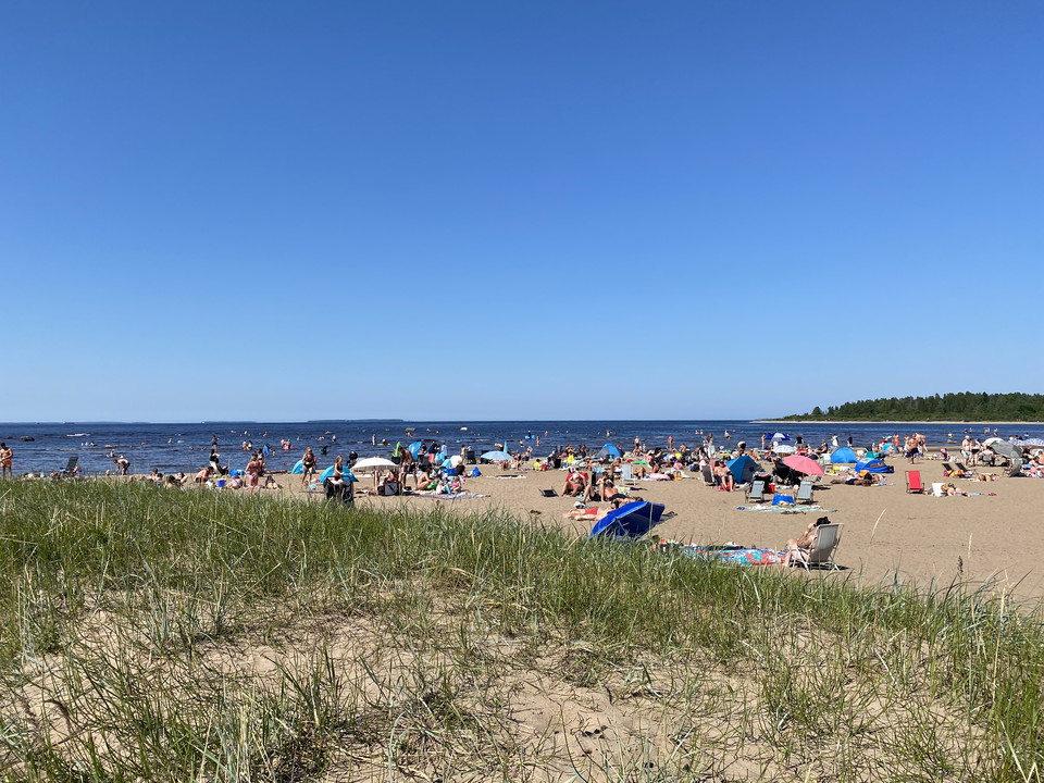 Stranden med många människor en solig dag