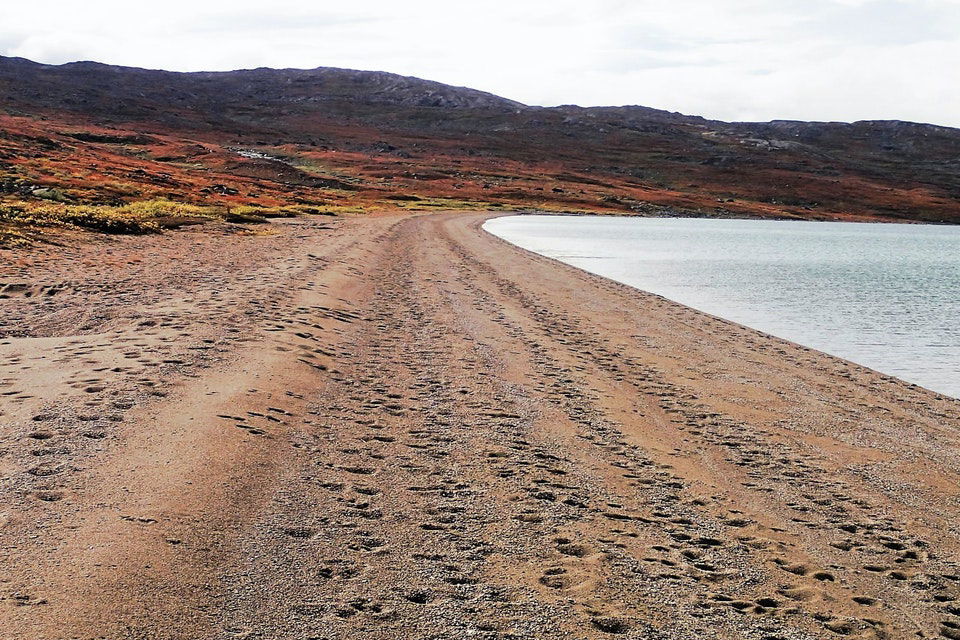 En fjällsjö med en lång sandstrand.