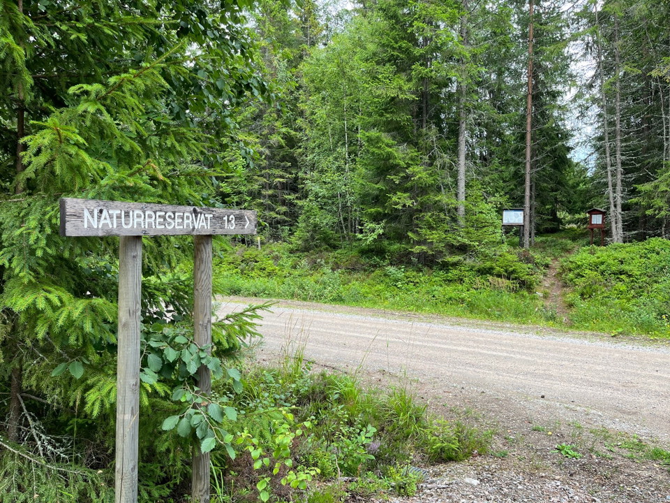 Skylt vid väg och liten p-plats