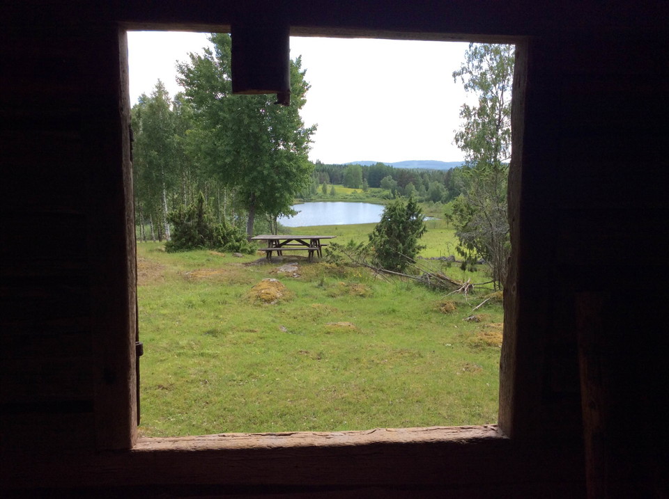 Vy ut från trösklogen över rastplats och sjö.