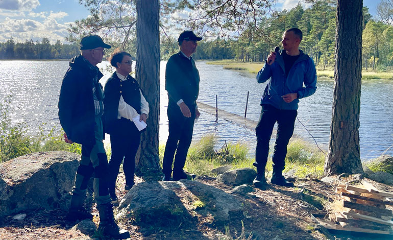 Talare uppställda med sjön Stora Acktjärnen som fond.