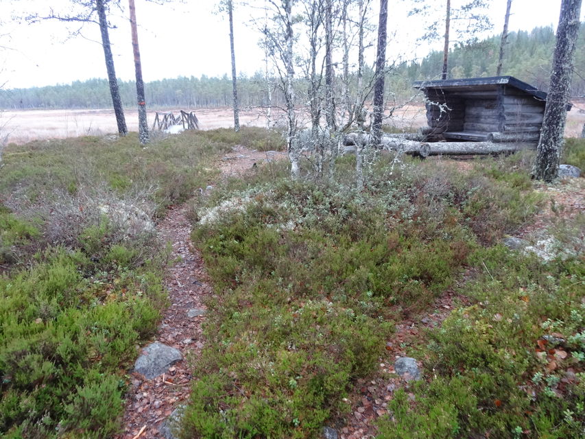 Stig som leder fram mot vindskydd och fortsätter bort mot ett tjärn.