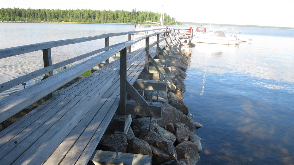 En träspång på en stenpir ut i havet.
