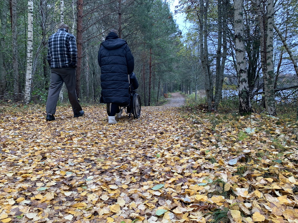 Två personer promenerar. Höstlöv på stigen