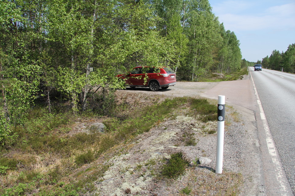 Parkering på grusplan intill landsvägen.