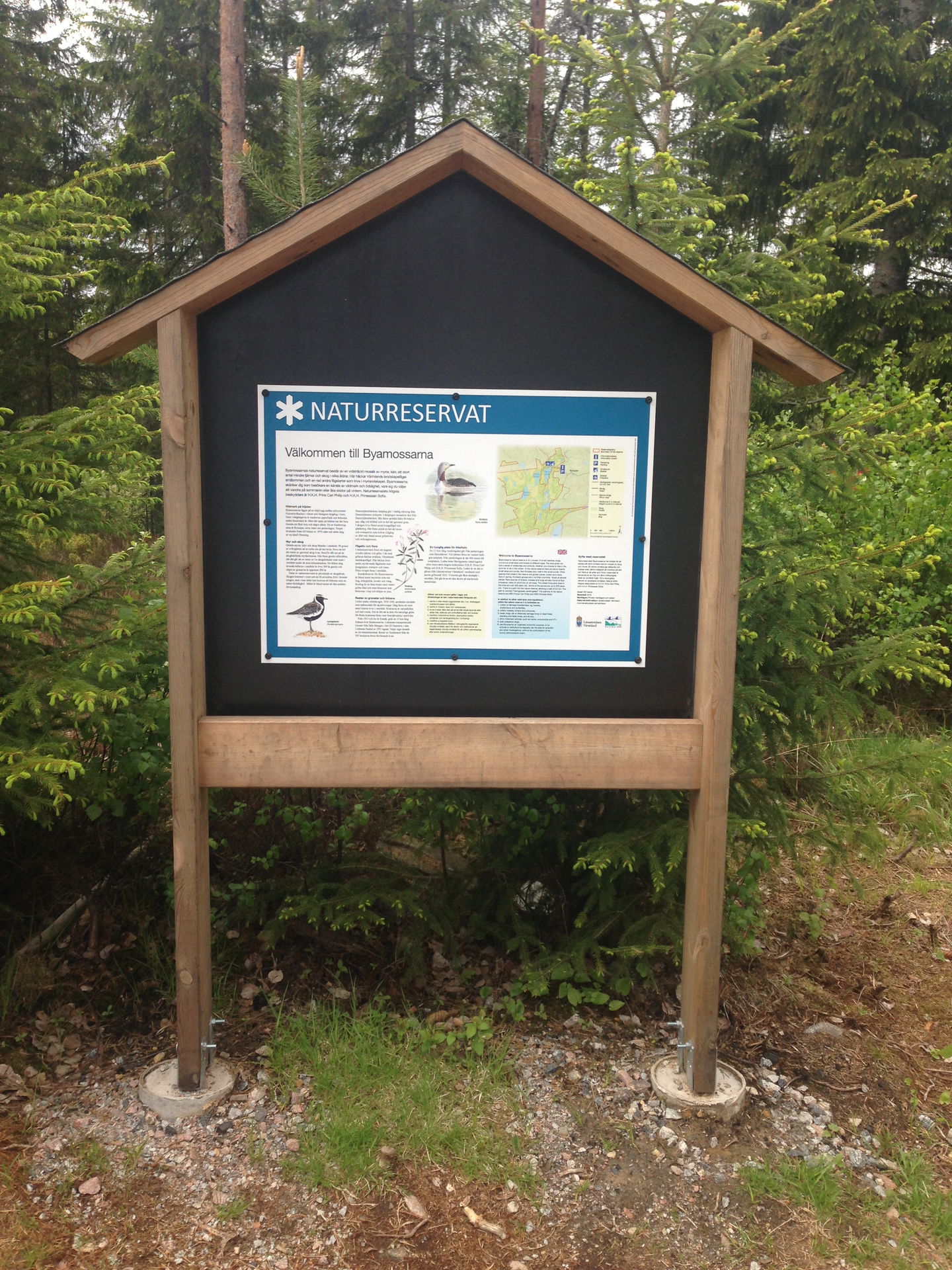 Informationsskylt i skogskanten.