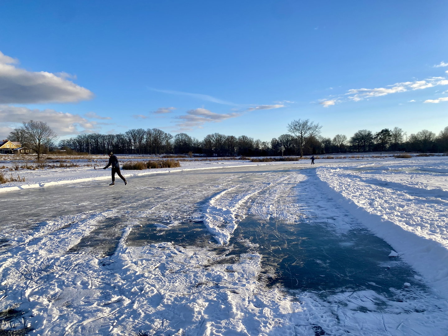 Skridskoåkare på isen med klubba