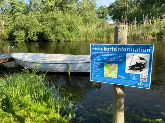 Informationsskylt om fiske vid Svartån i Sya