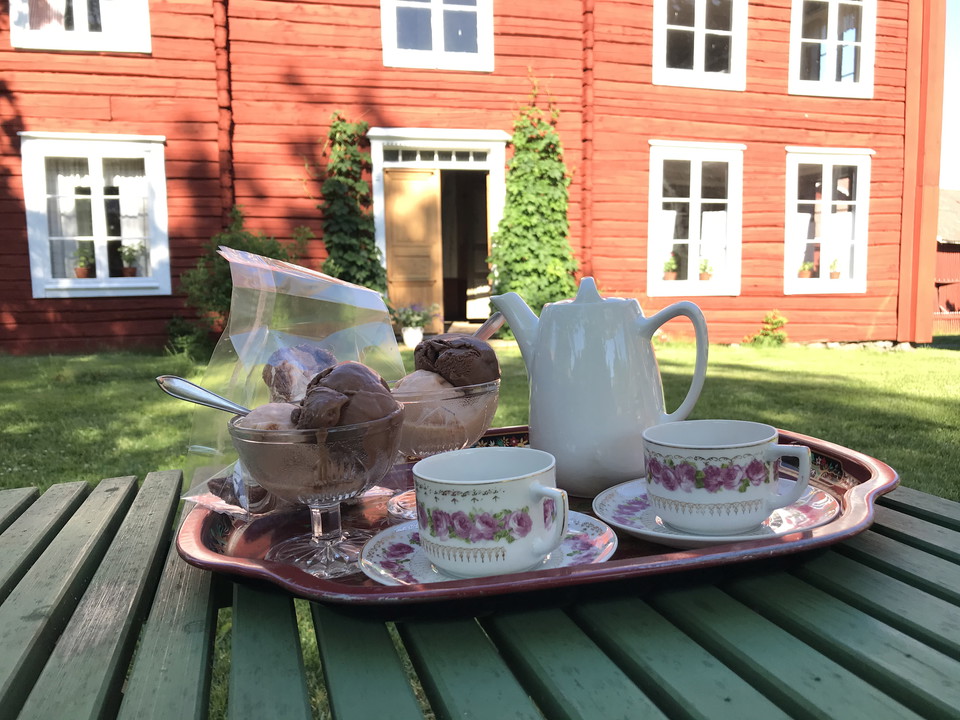 Fikabricka med kaffe och kaka i trädgårdskafé