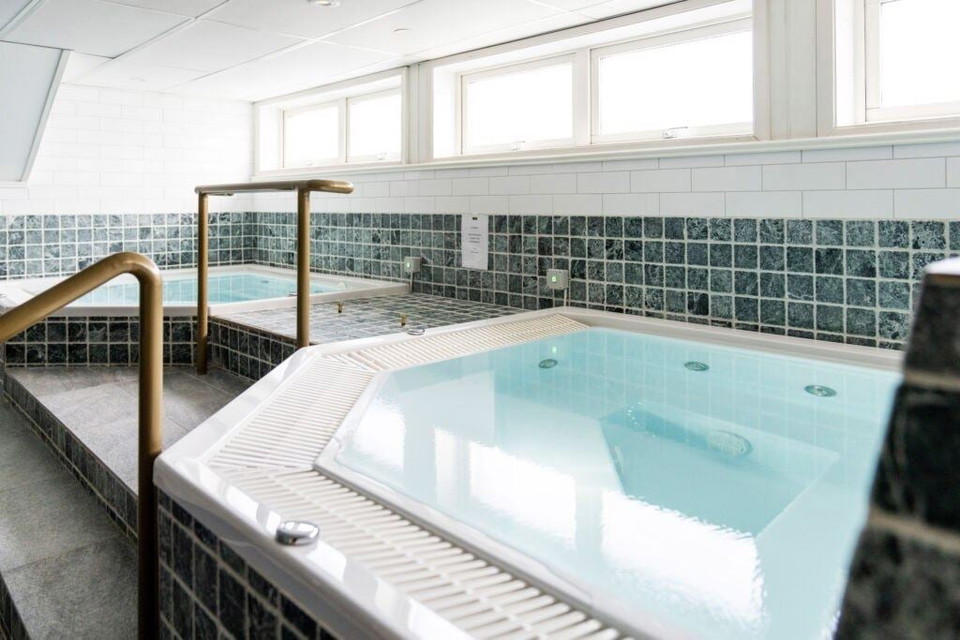 En stor badtunna i ett rum.