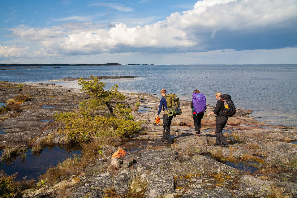 Vandrare som går över klippor vid havet