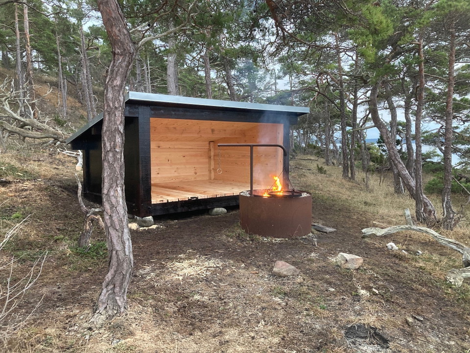 Vindskydd och grillplats i tallskog.